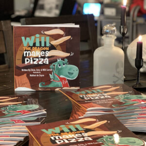 A picture of dozens of copies of a children's book named Will The Dragon Makes Pizza.